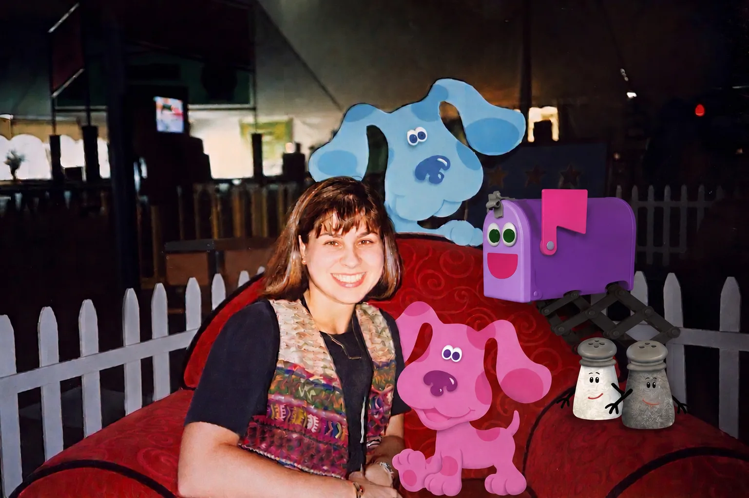 Allison Caplovitz. PhD sits in a red chair on the set of kids TV show Blue's Clues alongside several characters from show. Photo taken in 1998.